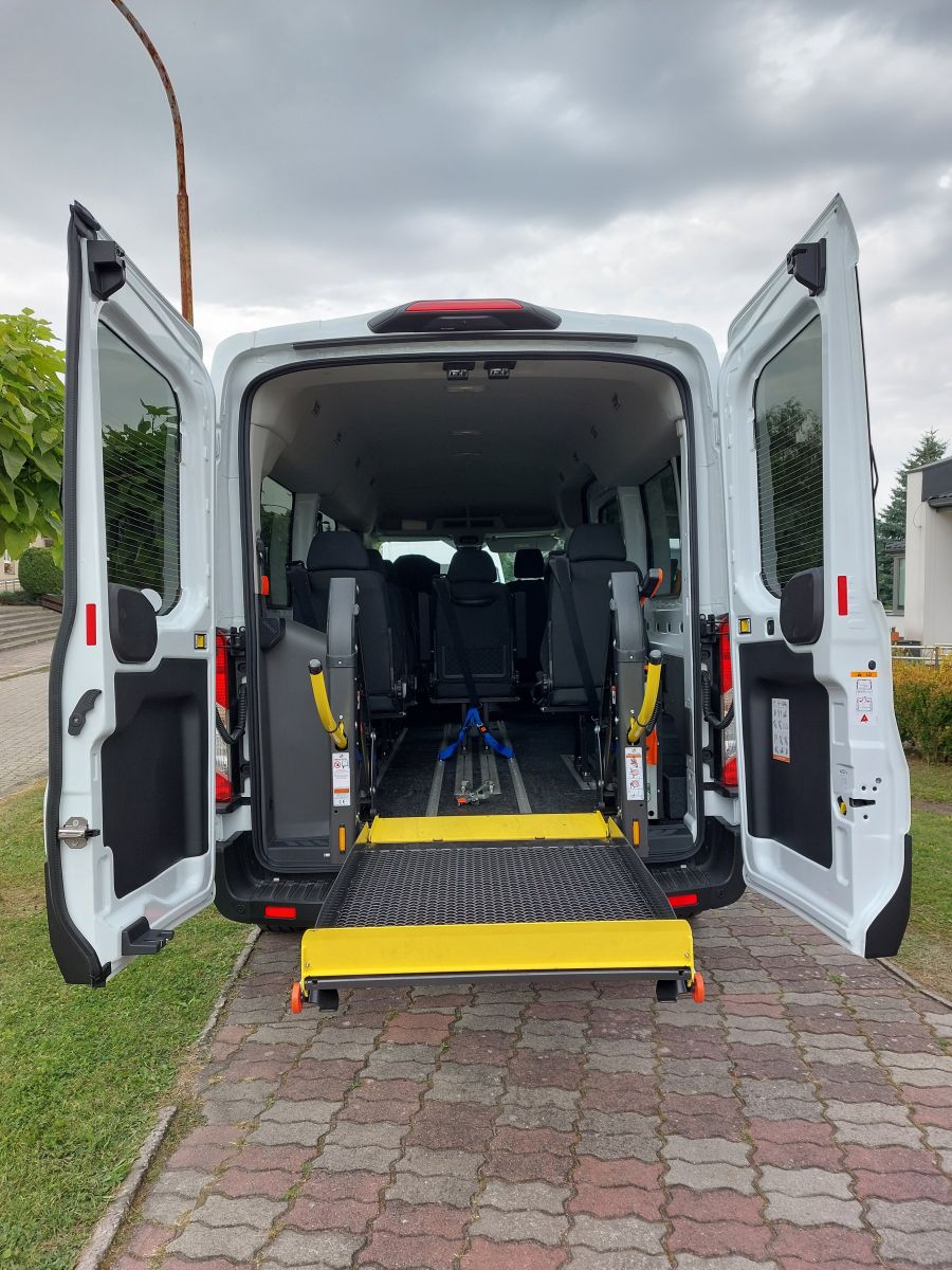 Mikrobus Ford Transit  z 9 - osobowy, dostosowany do przewozu os&oacute;b z niepełnosprawnościami, z rozłożoną windą hydrauliczną do wjazdu osoby na w&oacute;zku inwalidzkim