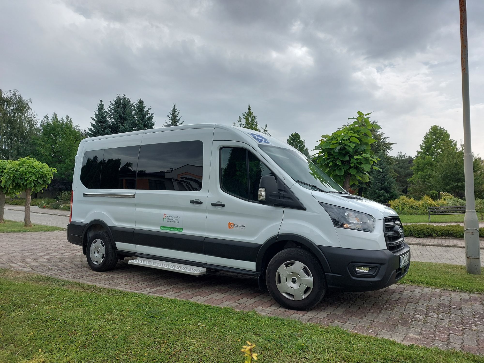 Mikrobus Ford Transit  z 9 - osobowy, dostosowany do przewozu os&oacute;b z niepełnosprawnościami, z logotypem PFRON i Gminy Miasto Rzesz&oacute;w