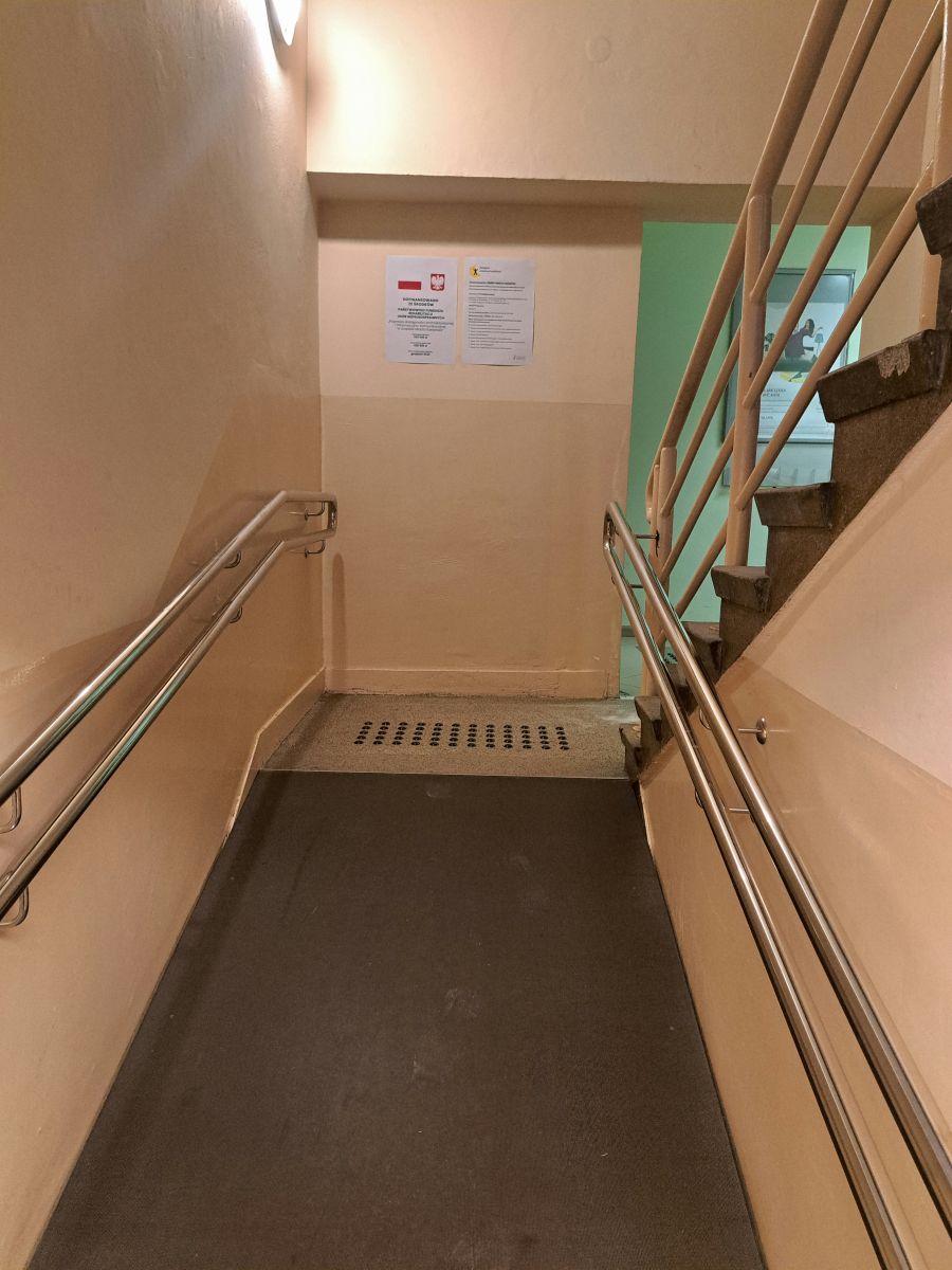 Wejście do budynku Urzędu Miasta Rzeszowa  przy ul. Okrzei 1  od strony ul. Kopernika z  zamontowanymi  poręczami nad podjazdem dla os&oacute;b z niepełnosprawnością ruchu